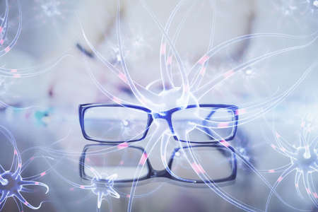 Neuron hologram over hands taking notes background. Concept of research and study. Double exposureの写真素材