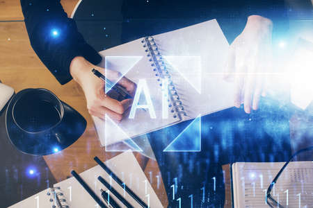 Double exposure of writing hands on background with data solution hologram on front. Technology...