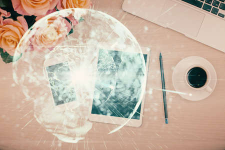Double exposure of business theme hologram over desktop with phone. Top view. Mobile international...