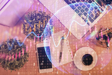 Multi exposure of financial chart hologram over desktop with phone. Top view. Mobile trade platform...