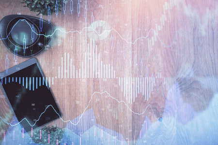Multi exposure of financial chart hologram over desktop with phone. Top view. Mobile trade platform...