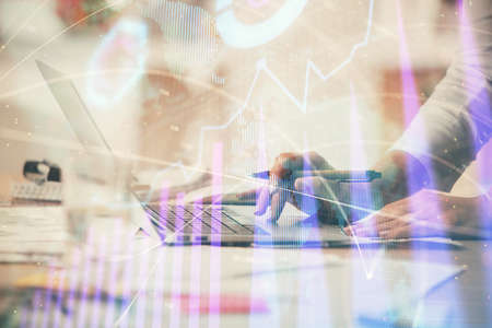 Double exposure of woman hands typing on computer and forex chart hologram drawing. Stock market invest concept.の写真素材