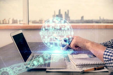 Double exposure of mans hands holding and using a phone and crypto currency blockchain theme...