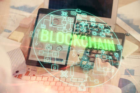 Double exposure of mans hands holding and using a phone and crypto currency blockchain theme...