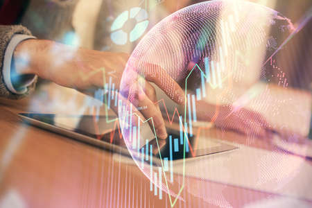 Double exposure of forex graph drawing and man and woman working together holding and using a mobile...