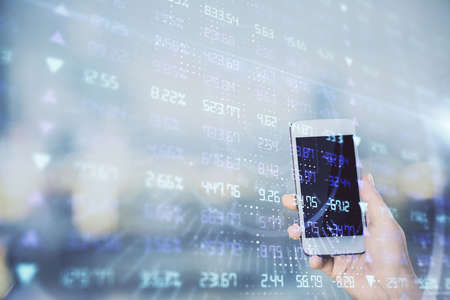 Double exposure of forex chart sketch hologram and woman holding and using a mobile device. Stock...