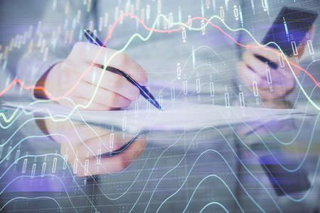 Double exposure of forex chart sketch hologram and woman holding and using a mobile device....