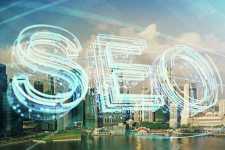 SEO hologram on city view with skyscrapers background double exposure. Search optimization concept.の写真素材