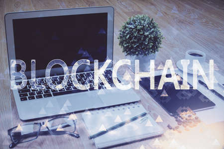 Double exposure of blockchain and crypto economy theme hologram and table with computer background....