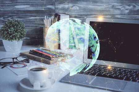 Computer on desktop with social network hologram. Double exposure. Concept of international people connections.の写真素材