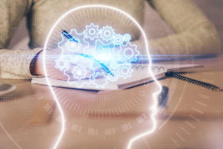 Double exposure of womans writing hand on background with brain hud. Concept of learning.