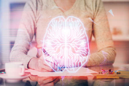 Double exposure of writing hand on background with brain hologram. Concept of learning.の写真素材