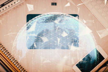 Double exposure of business theme hologram over desktop with phone. Top view. Mobile international trade connection concept.の写真素材