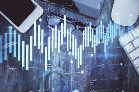 Multi exposure of forex graph hologram over desktop with phone. Top view. Mobile trade platform...