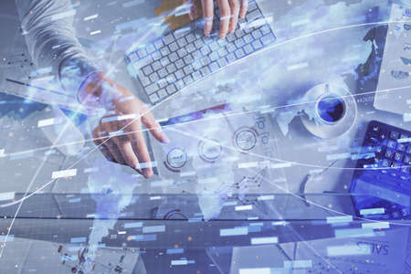 Double exposure of mans hands typing over computer keyboard and data theme hologram drawing. Top view. Technology concept.の写真素材