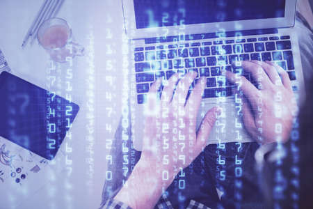 Multi exposure of mans hands typing over computer keyboard and data theme hologram drawing. Top...