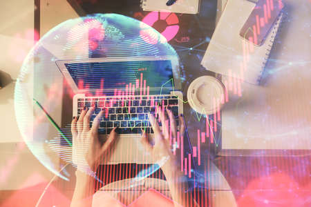 Double exposure of woman hands working on computer and financial theme hologram drawing. Top View....