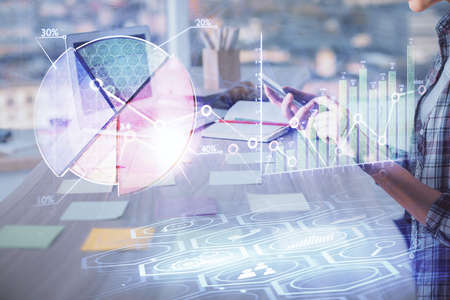Double exposure of woman hands working on computer and forex graph hologram drawing. Financial...