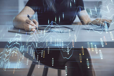 Double exposure of businesswoman hands typing on computer and forex chart hologram drawing....