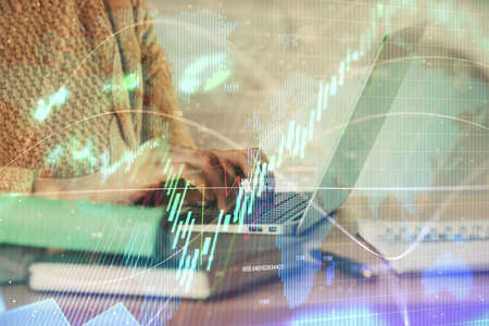 Double exposure of woman hands typing on computer and forex chart hologram drawing. Stock market...