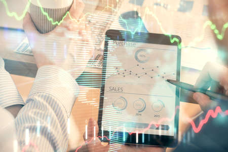 Double exposure of mans hands holding and using a phone and financial chart drawing. Market analysis...