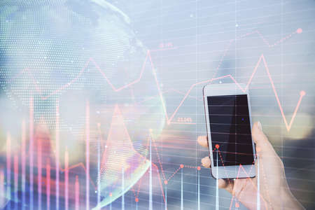 Double exposure of forex chart sketch hologram and woman holding and using a mobile device. Stock...