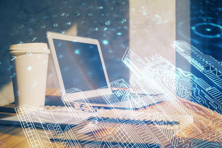 Desktop computer background in office and big town buildings hologram drawing. Double exposure....