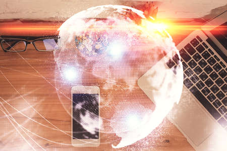 Double exposure of business theme hologram over desktop with phone. Top view. Mobile international trade connection concept.の写真素材