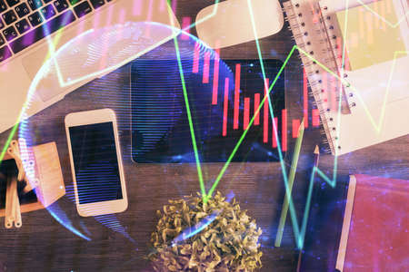 Double exposure of forex chart hologram over desktop with phone. Top view. Mobile trade platform concept.の写真素材