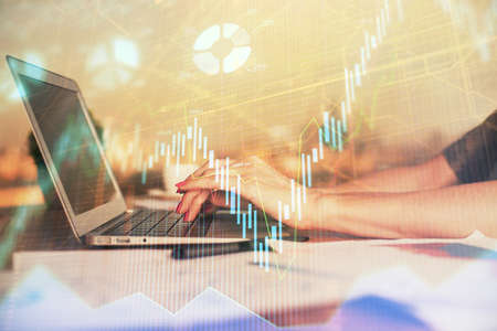 Double exposure of businesswoman hands typing on computer and forex chart hologram drawing....