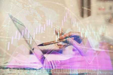 Multi exposure of woman hands typing on computer and financial graph hologram drawing. Stock market...