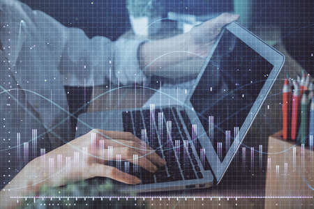 Double exposure of woman hands typing on computer and forex chart hologram drawing. Stock market...