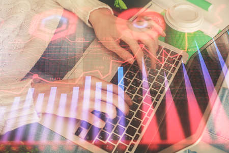 Double exposure of woman hands typing on computer and forex chart hologram drawing. Stock market...