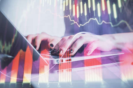 Double exposure of woman hands typing on computer and forex chart hologram drawing. Stock market...