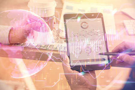 Double exposure of mans hands holding and using a phone and financial chart drawing. Market analysis...