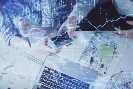 Double exposure of forex graph drawing and man and woman working together holding and using a mobile...
