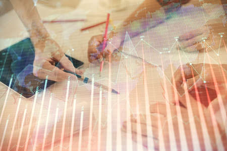 Double exposure of forex graph drawing and man and woman working together holding and using a mobile...