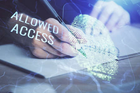 Blue fingerprint hologram over hands taking notes background. Concept of security. Double exposure
