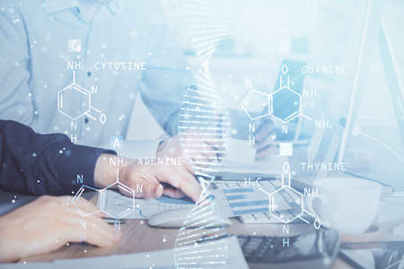 DNA hologram with businessman working on computer on background. Concept of bioengineering. Double...