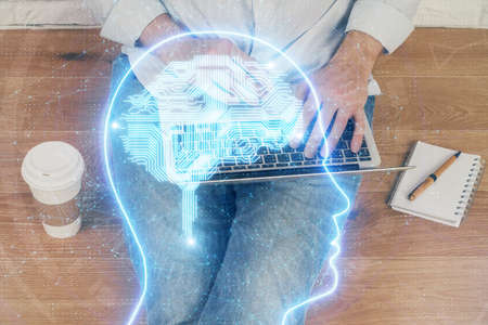 Businessman with computer background with brain theme hologram. Concept of brainstorm. Multi...