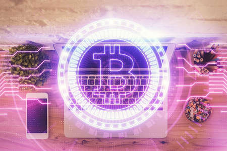 Blockchain theme hologram drawings over computer on the desktop background. Top view. Multi...