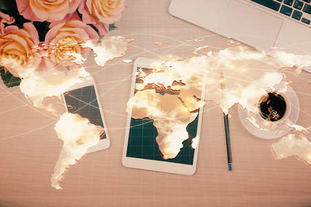 Double exposure of business theme hologram over desktop with phone. Top view. Mobile international...