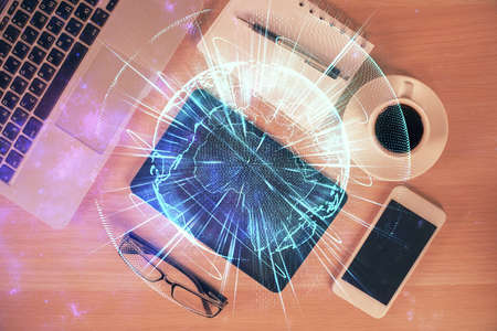 Double exposure of business theme hologram over desktop with phone. Top view. Mobile international...