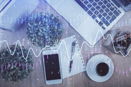 Multi exposure of financial chart hologram over desktop with phone. Top view. Mobile trade platform concept.の写真素材