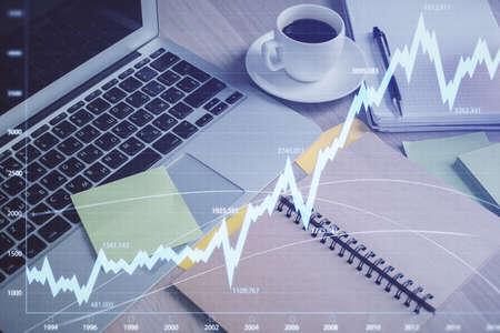 Multi exposure of forex graph drawing and desktop with coffee and items on table background. Concept...