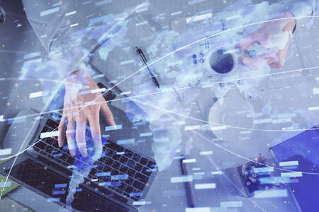Double exposure of mans hands typing over computer keyboard and data theme hologram drawing. Top view. Technology concept.の写真素材