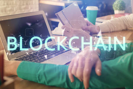 Double exposure of man and woman working together and crypto finance theme hologram. Blockchain...
