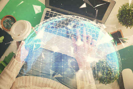 Double exposure of woman hands working on computer and financial theme hologram drawing. Top View. Business concept.の写真素材