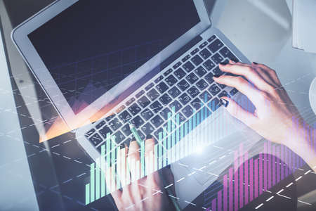 Double exposure of woman hands working on computer and forex chart hologram drawing. Top View....