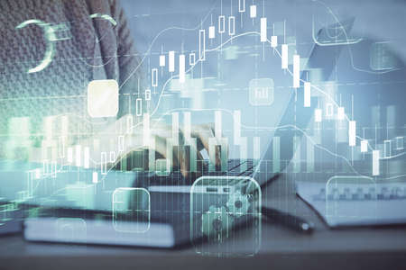Double exposure of woman hands typing on computer and forex chart hologram drawing. Stock market...